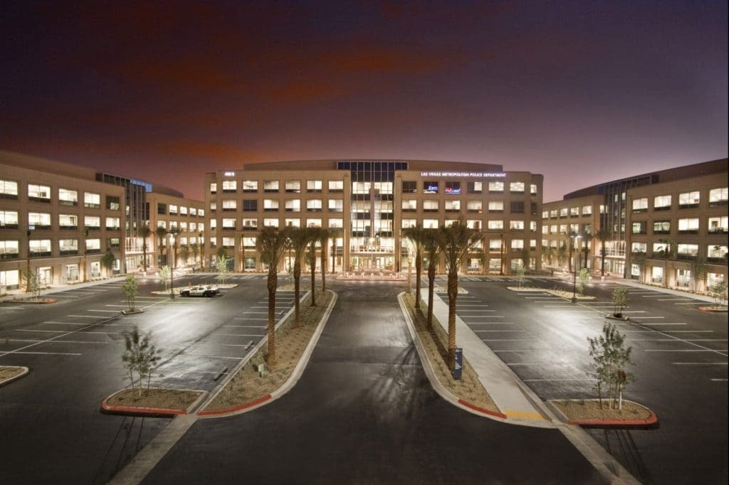 Las Vegas Metropolitan Police Department office building with three wings, palm trees lining the entrance, and an empty parking lot at dusk built by PENTA.
